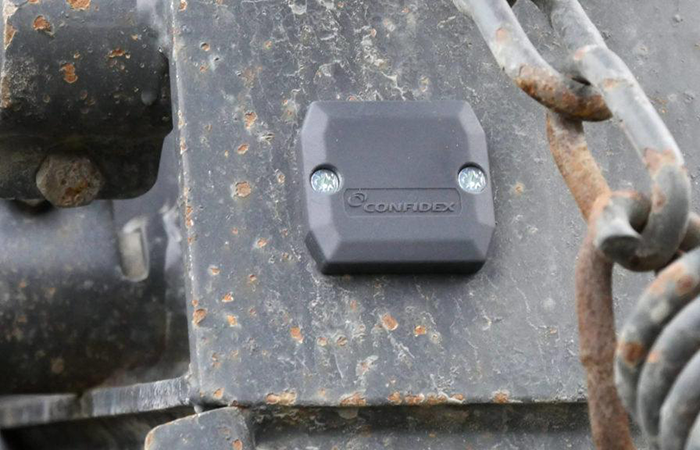 The image showcases a rugged Confidex RFID tag securely attached to a metal surface