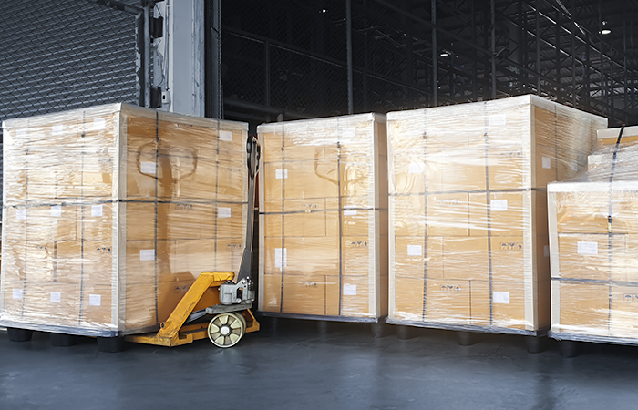 A warehouse showcasing efficient organization and storage solutions with neatly stacked pallets wrapped in plastic