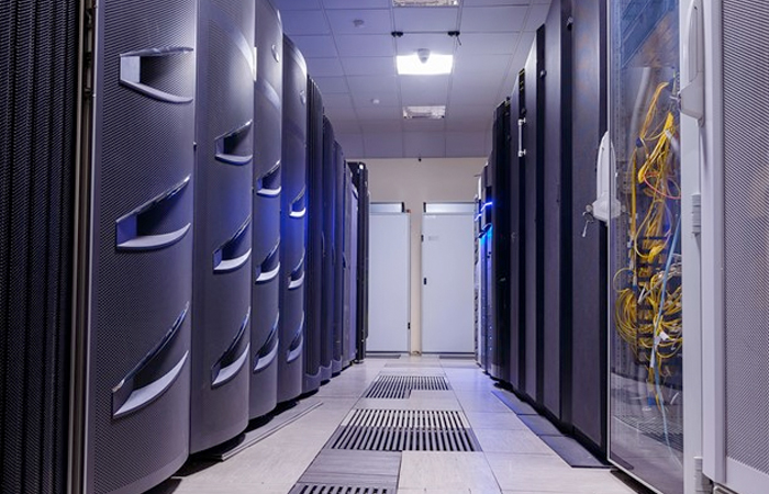 Server racks in a modern data center with blue lighting, representing Impinj's advanced technology infrastructure.