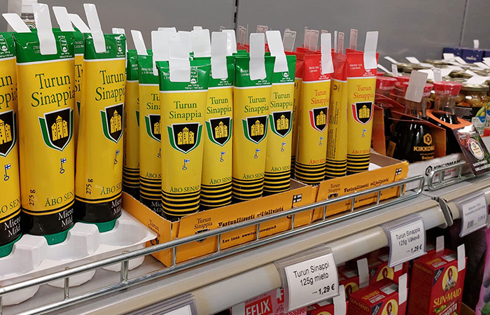 Rows of Turun Sinappi mustard tubes are neatly lined up on a grocery