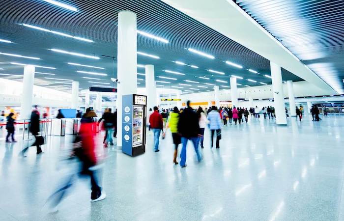 Impinj intelligent information cabinet in a busy airport terminal with passengers in motion, highlighting seamless travel technology