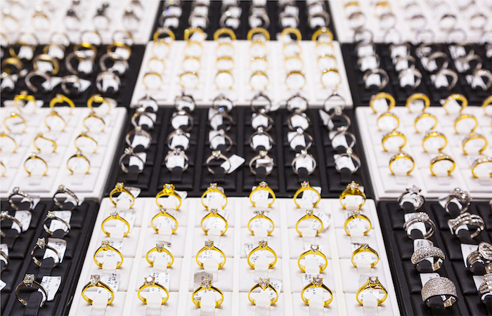 Rows of various rings displayed on black and white trays, showcasing a selection of gold