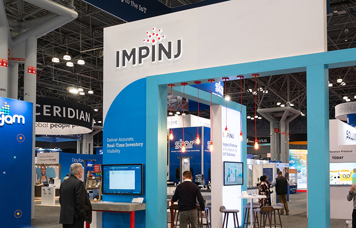 two people visiting the Impinj booth at NRF 2024