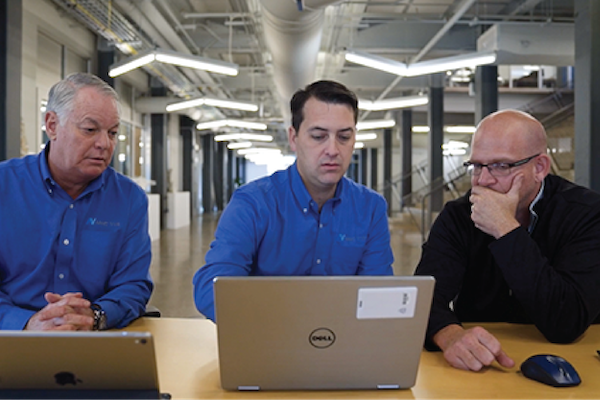 three-people-looking-at-a-laptop