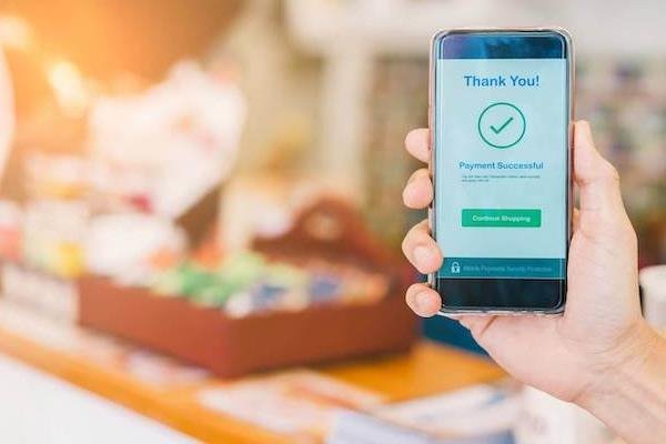 Customer completing a cashier-less payment using a smartphone in a store, with Impinj's technology improving shopping experiences.