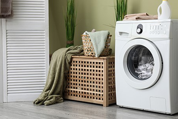 A modern laundry room equipped with a white front-loading washing machine, neatly placed beside
