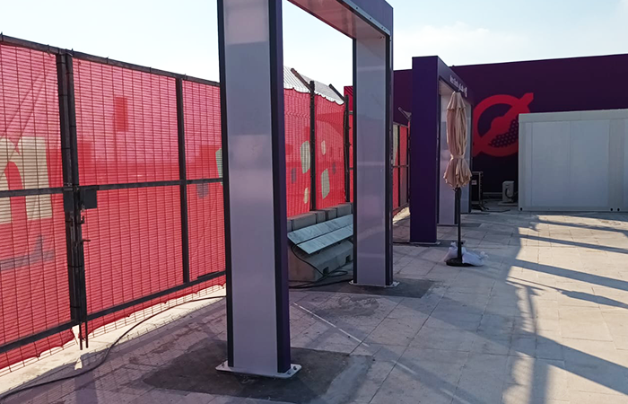 The image displays a modern bus stop with a sleek design, featuring a metal bench