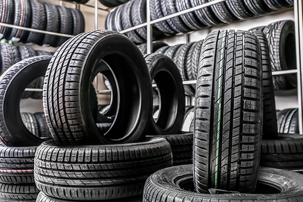 The image showcases a selection of various car tires stacked in an organized manner on metal
