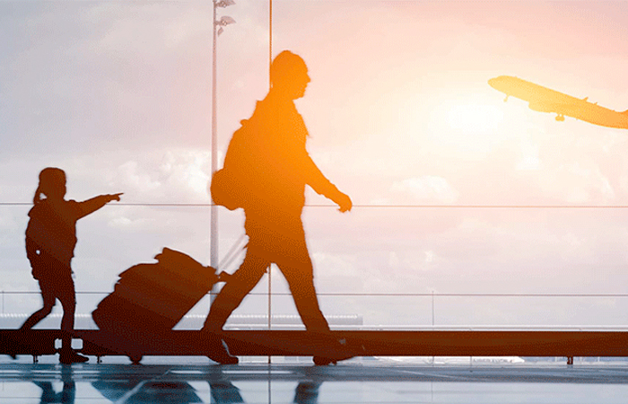 The image captures a moment at an airport with a silhouette of a person walking brisk