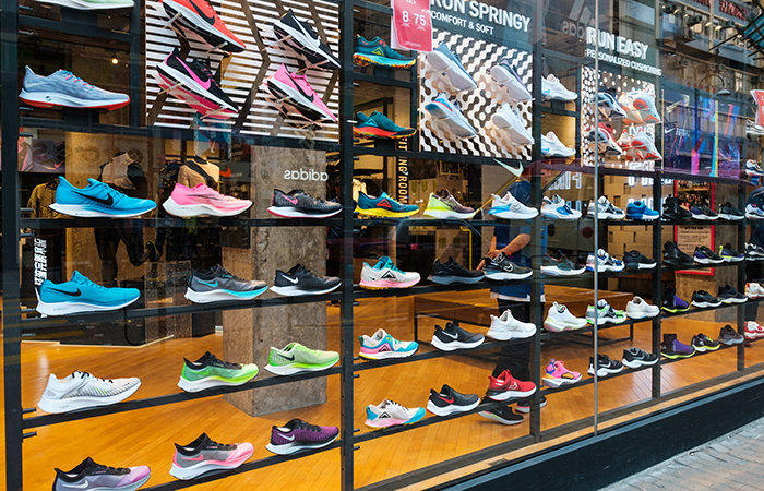 A vibrant display of various athletic shoes in a store window, showcasing a wide array