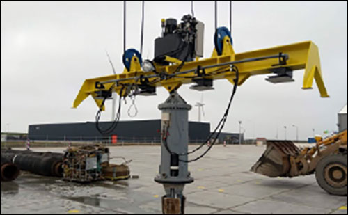 An industrial lifting device with a yellow beam and multiple hoists is positioned in a
