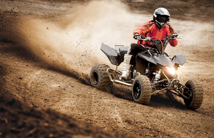 An adrenaline-charged ATV rider kicks up a cloud of dust while expertly maneuver