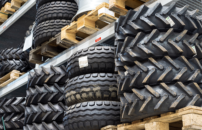 Stacks of heavy-duty vehicle tires are methodically organized on warehouse shelving,