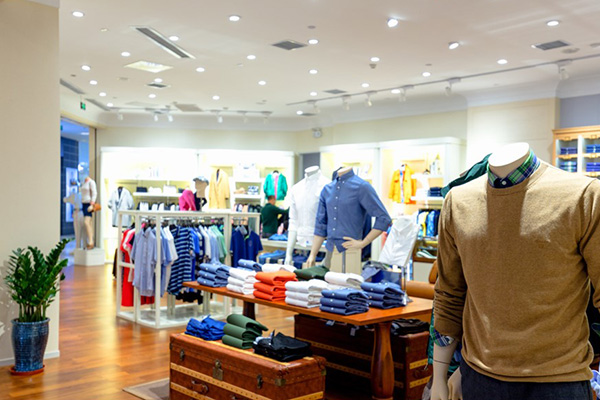 Interior de una tienda de ropa moderna y ordenada, con man