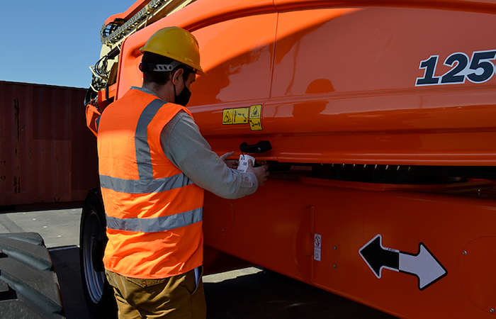 Worker in safety gear using industrial equipment with Impinj technology for enhanced functionality and user experience