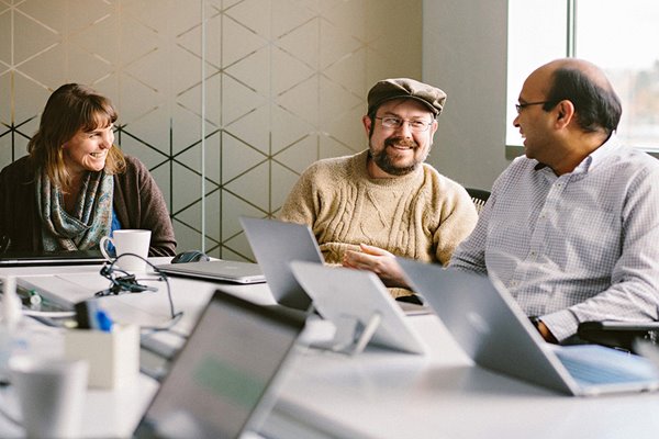 Mitarbeiter-sitzen-an-einem-Tisch-bei-einem-Meeting