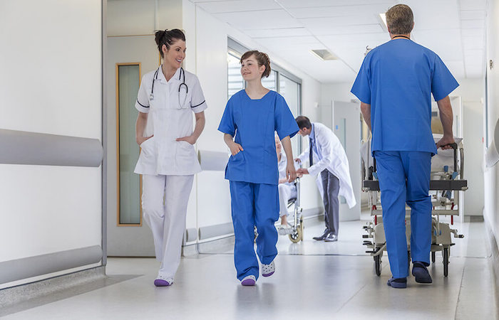 Healthcare professionals in motion in a hospital corridor, depicting the dynamic environment of medical