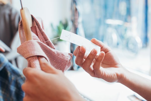 Picture of someone checking a price tag on shirt