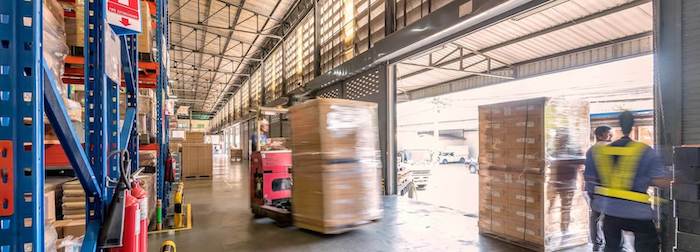 Active warehouse operation with worker and forklift, reflecting Impinj's commitment to efficiency and enhanced user experience.