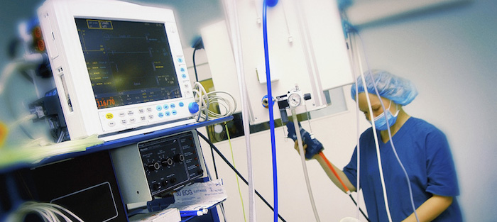 Healthcare professional operating a vital signs monitoring system in a medical facility, demonstrating Impinj's commitment to innovative technology and user experience.