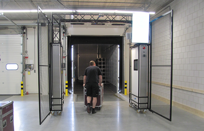 The image captures a worker maneuvering a hand truck through the expansive entryway of