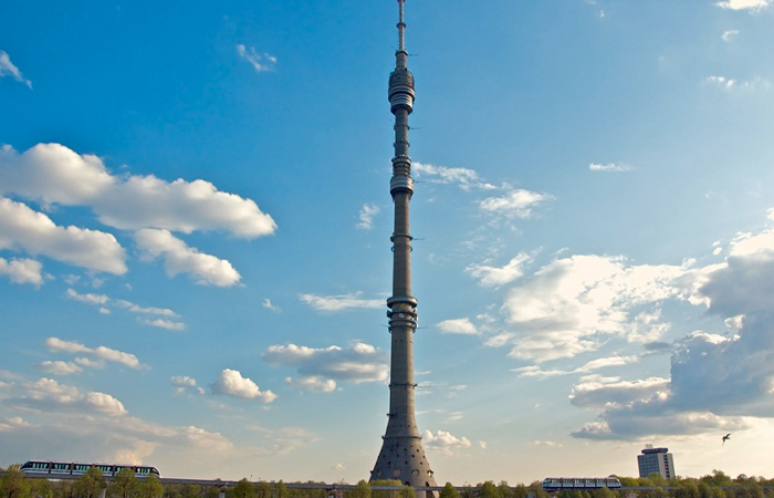The Ostankino Tower stands tall against a backdrop of blue skies dotted with fluffy