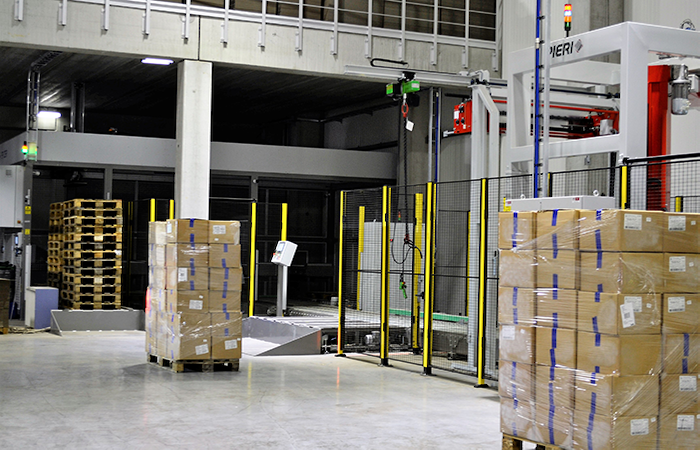 Inside a modern warehouse, pallets of boxed goods are prepared for distribution, showcasing
