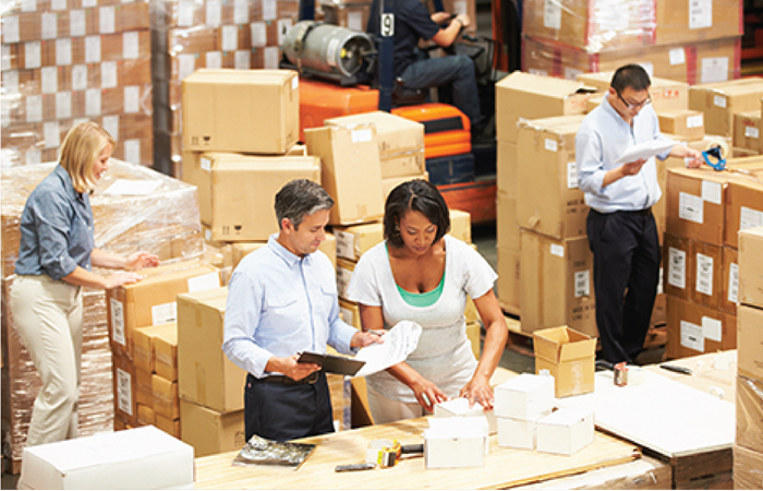A bustling warehouse scene where a diverse team of workers are engaged in various tasks such
