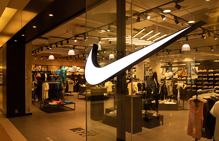 The image showcases the iconic Nike swoosh logo prominently displayed on the glass facade of