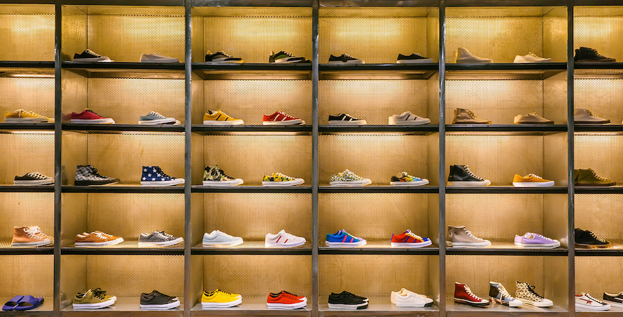 A well-organized display of various sneakers in a retail store, showcasing an array