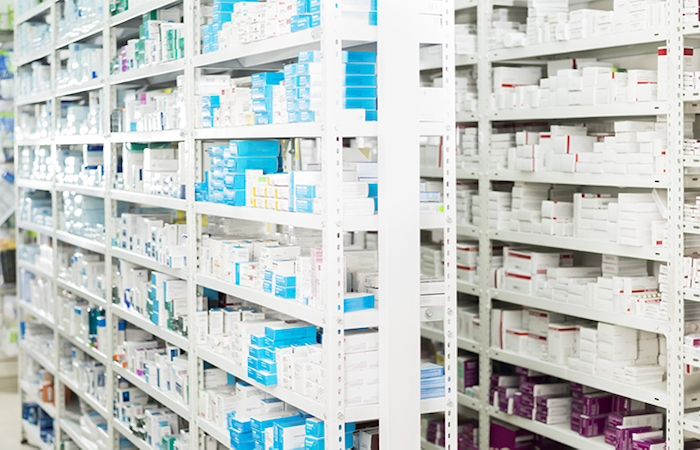 The image showcases an array of pharmaceutical products meticulously organized on white shelving units,