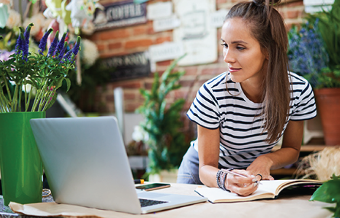 A woman in a striped t-shirt is engaged in an attentive study session at a