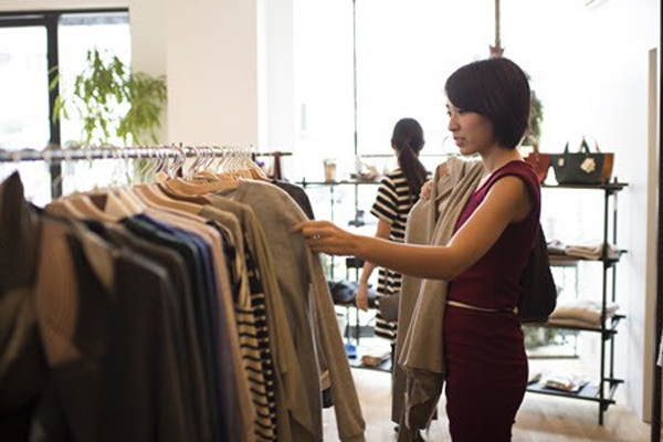 A customer browses through a selection of clothing at a modern, well-lit