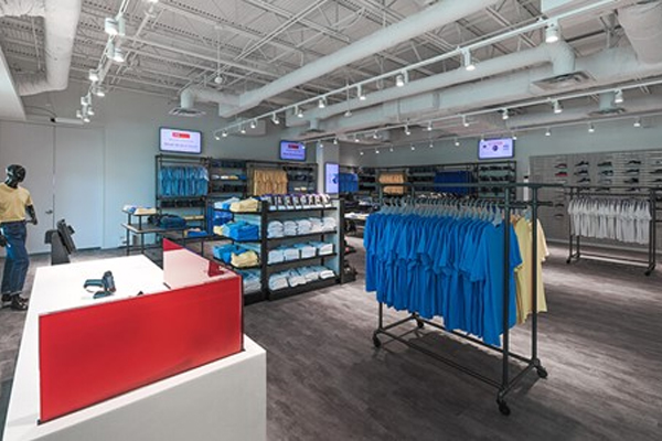 This modern retail clothing store interior showcases a neatly organized space with a variety of garments