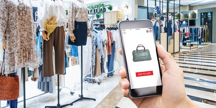 In this dynamic image, we see a shopper's hand holding a smartphone within a